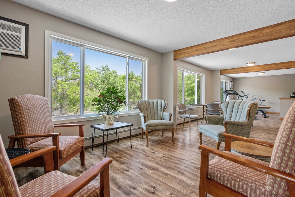 a living room with chairs and a large window