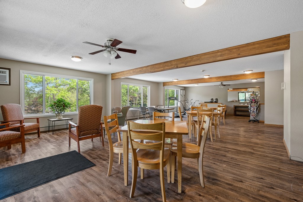 a dining area with tables and chairs and a ceiling fan