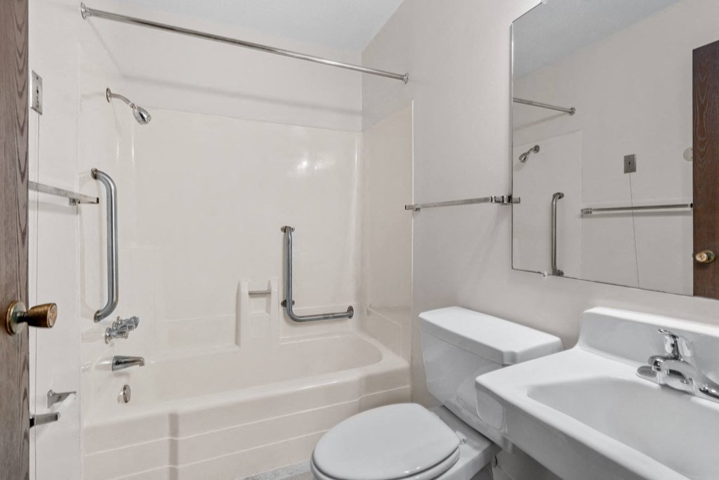 a white bathroom with a tub and a toilet and a sink