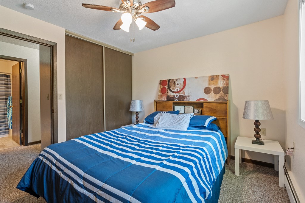 a bedroom with a bed and a ceiling fan