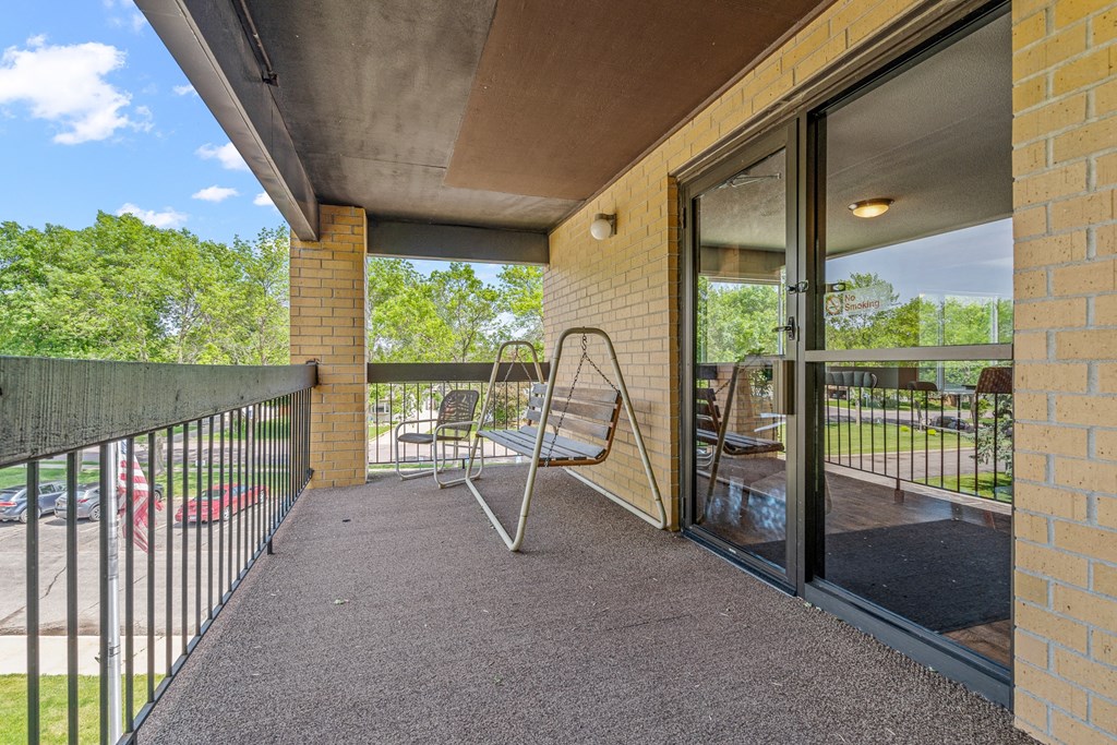 a balcony with a chair and a glass door