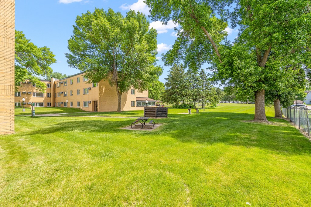 a park with trees and a bench in front of a building