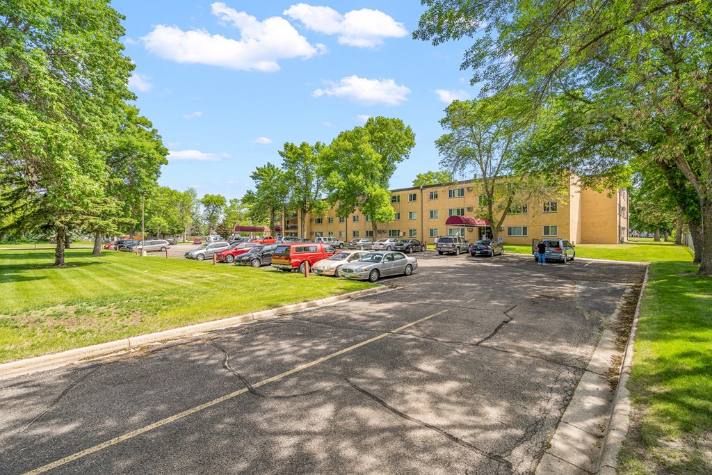 a parking lot with cars parked in front of a building