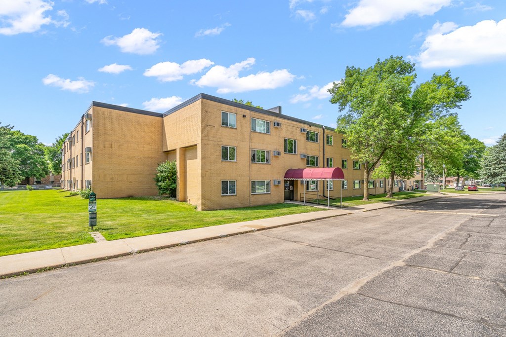 a brick building with a red awning on the corner of a street