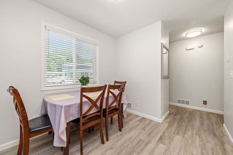A dining room with a table and chairs.