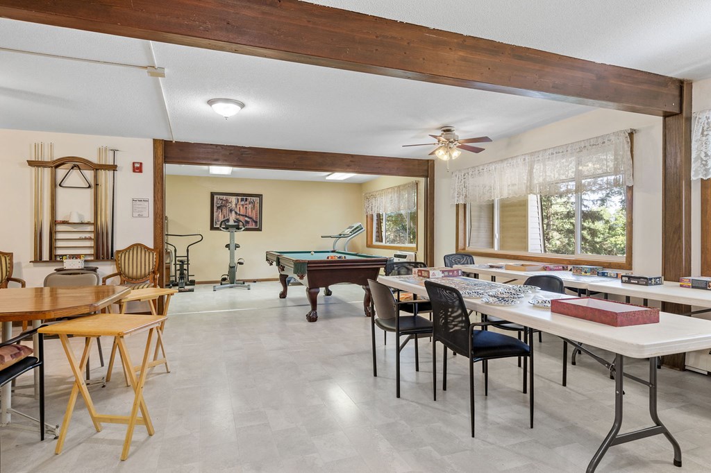 a game room with tables and chairs and a pool table