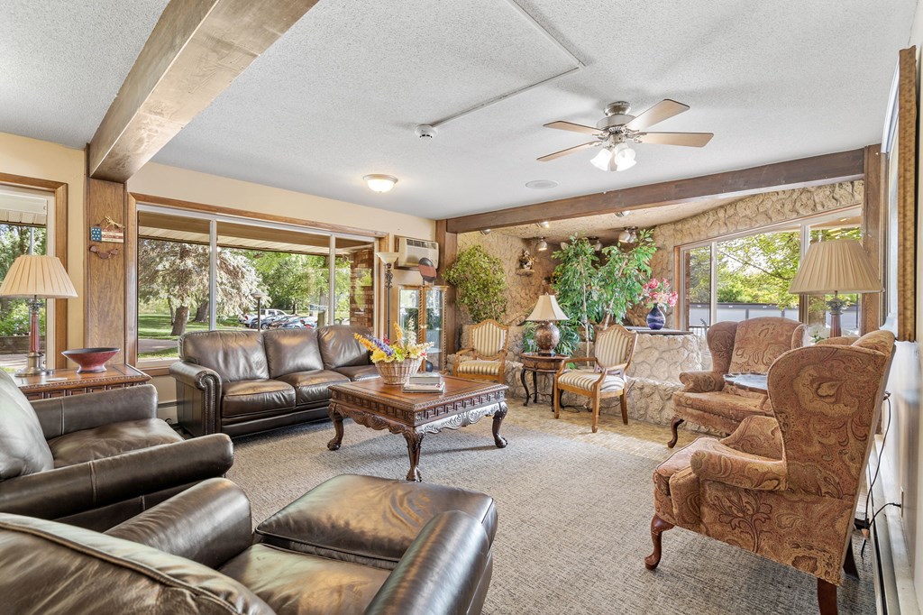 a living room with leather furniture and a ceiling fan