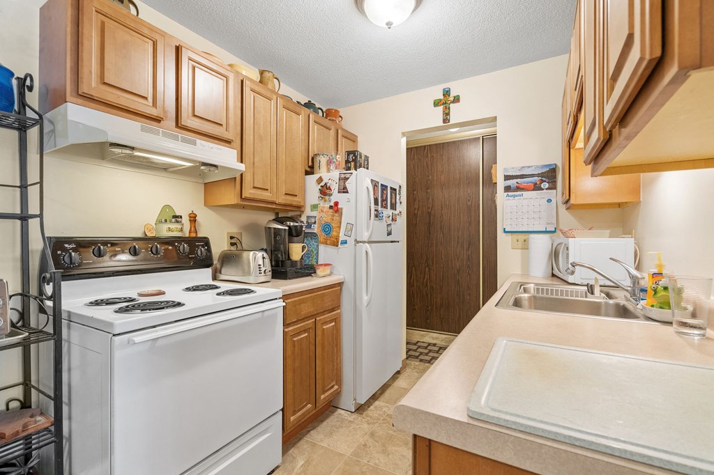 a kitchen with white appliances and wooden cabinets