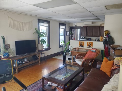 A living room with a brown couch and a television.