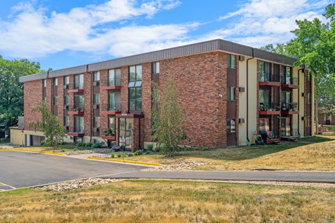 a brick apartment building with a road in front of it
