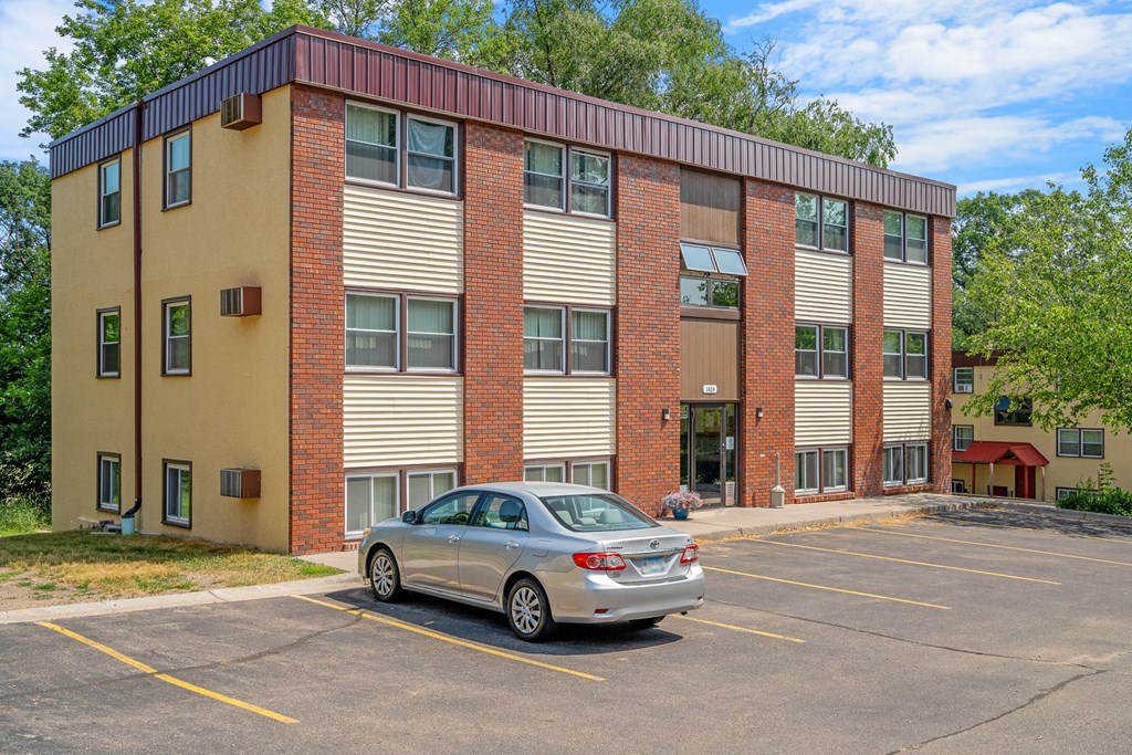 a silver car parked in front of a brick building