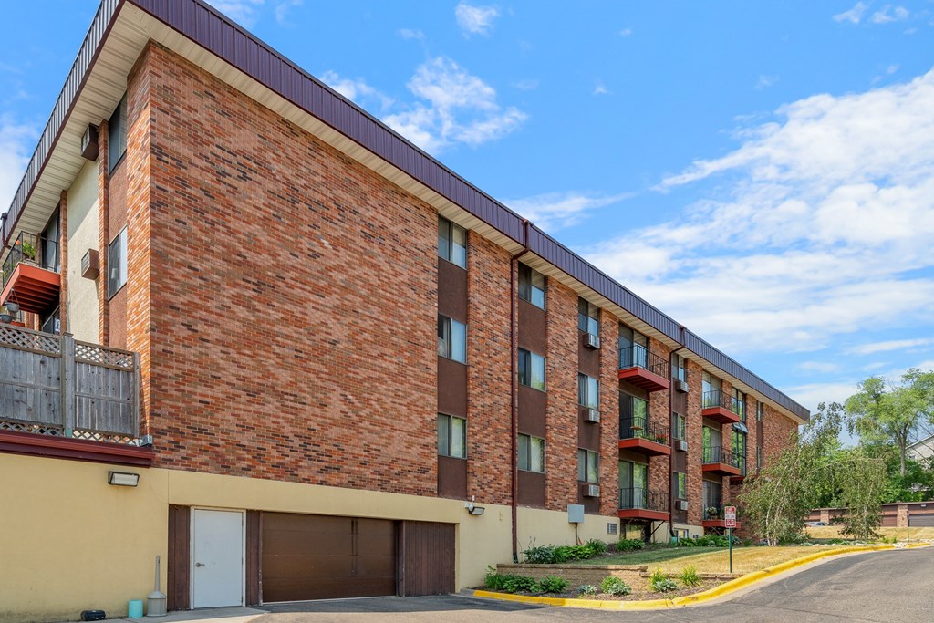 a red brick apartment building with a street in front of it