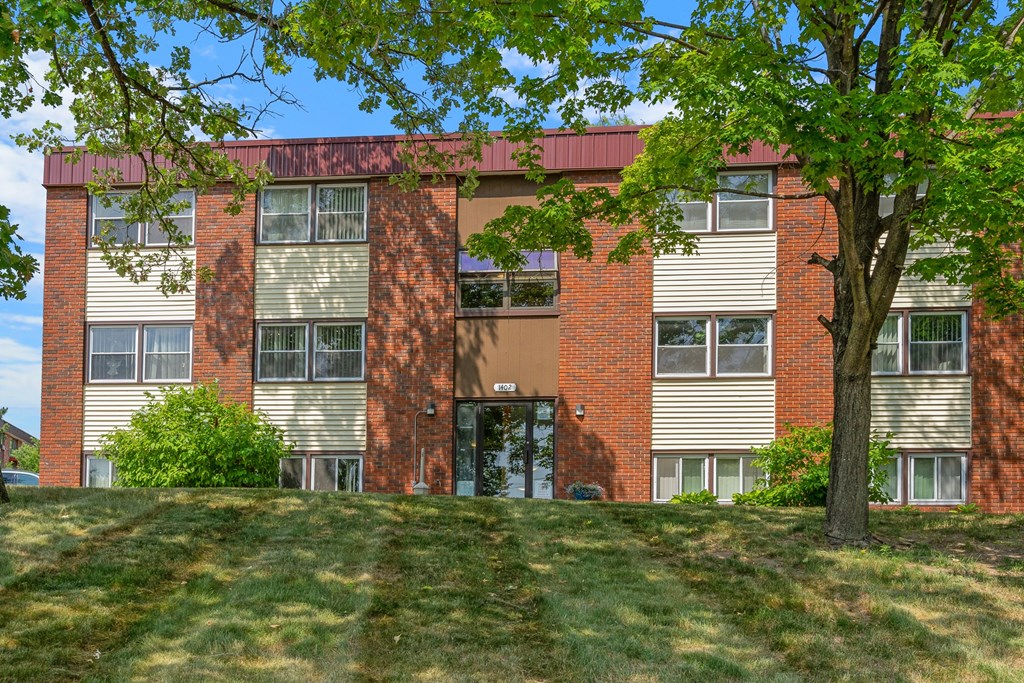 a red brick building with a tree in front of it