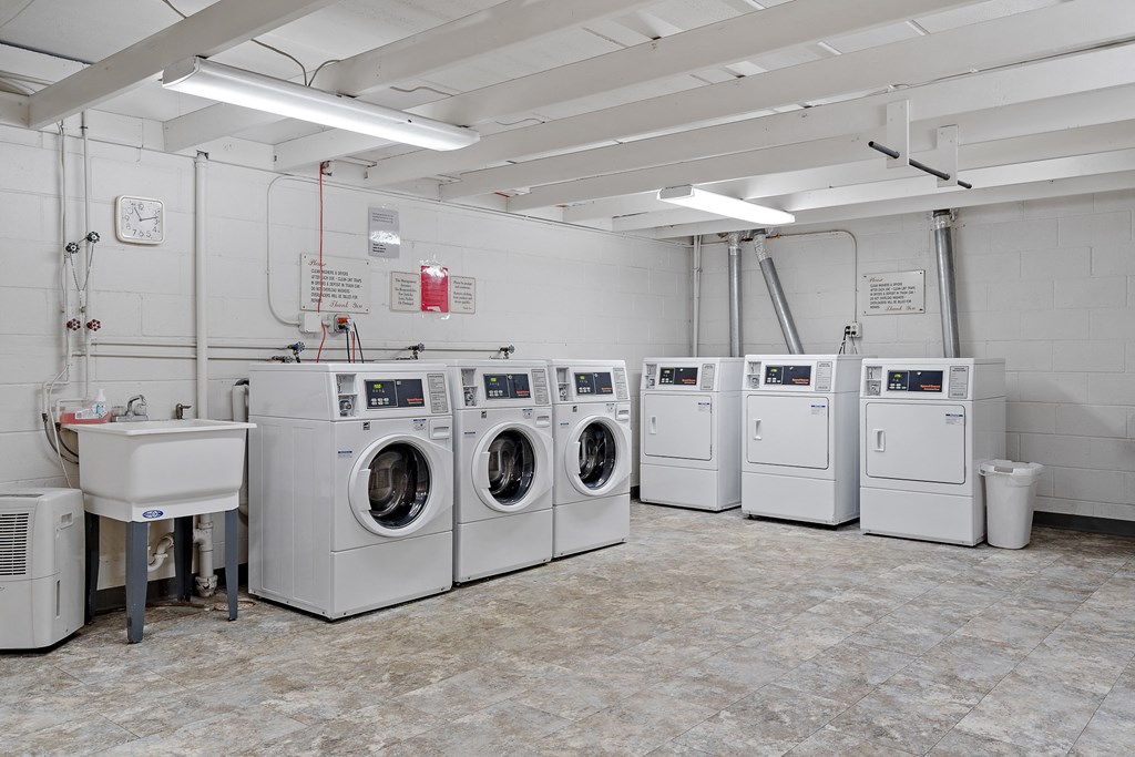 a laundry room with a row of washing machines in it