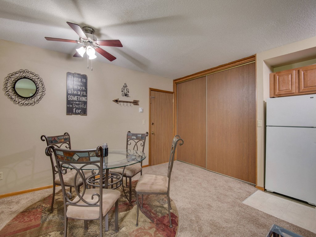 a dining room with a table and chairs and a refrigerator