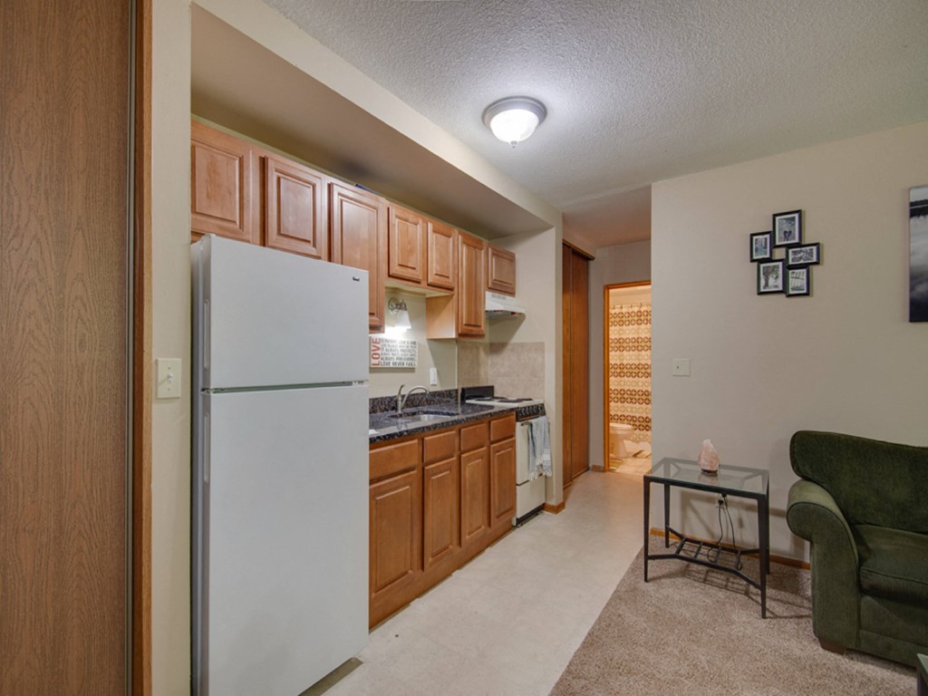 a kitchen with white appliances and wooden cabinets and a white refrigerator
