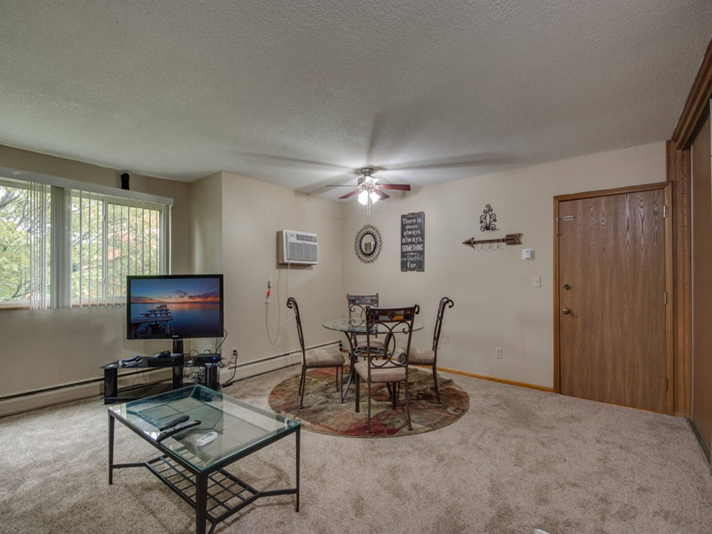 a living room with a table and chairs and a television