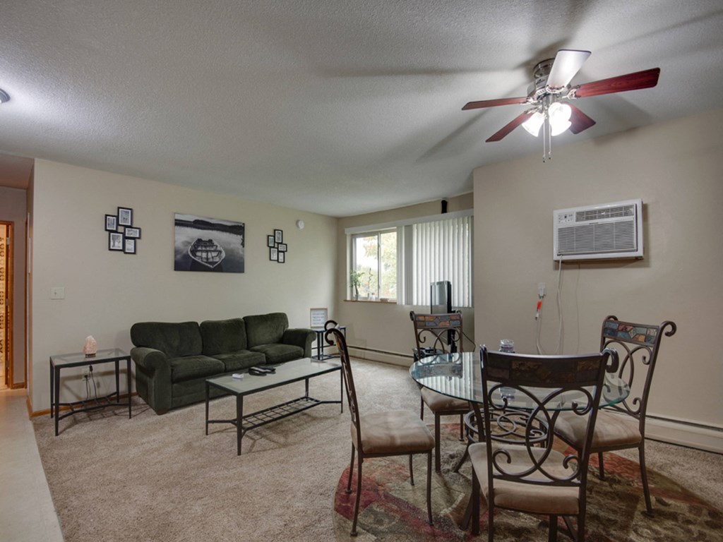 a living room with a couch and a table and a ceiling fan