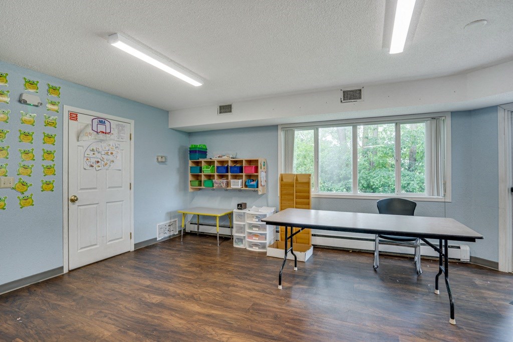 a classroom with a table and chairs in front of a window