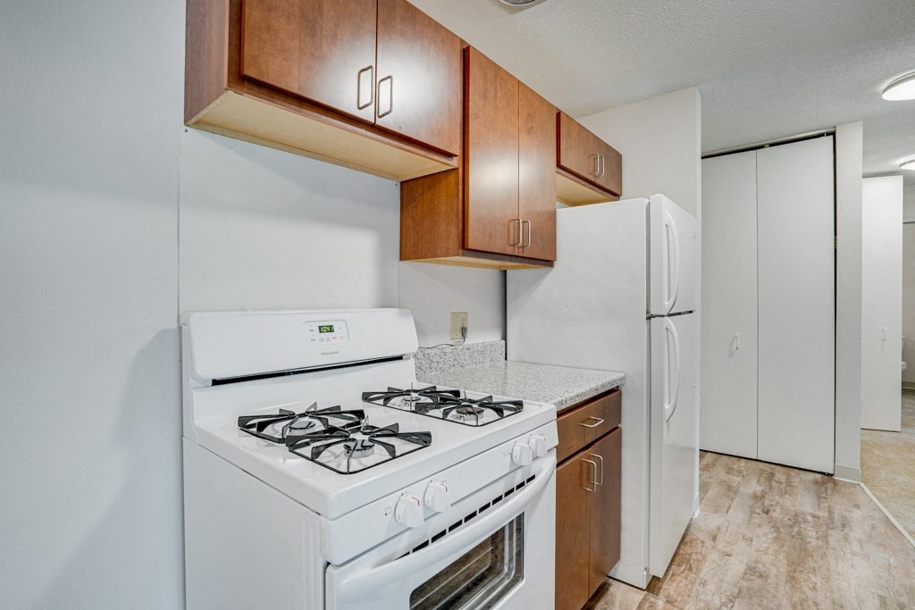 a kitchen with white appliances and wooden cabinets and a white refrigerator