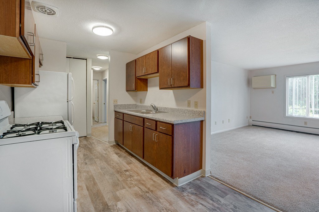 an empty kitchen with wooden cabinets and a stove top oven