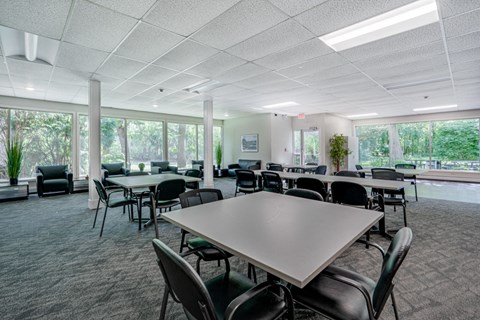 a large room with tables and chairs and windows