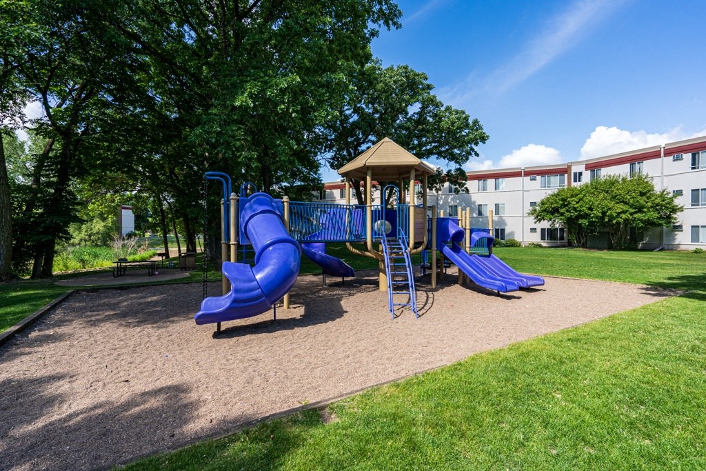 a playground with blue slides and a gazebo