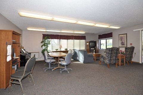 A conference room with a table, chairs, and a television.