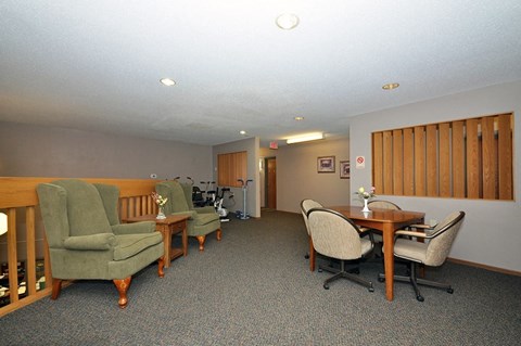 A room with a table and chairs in the middle of the room.