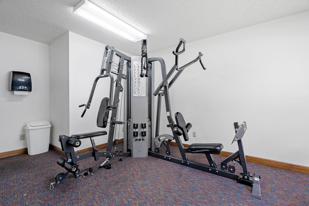 a gym with exercise equipment in the corner of a room