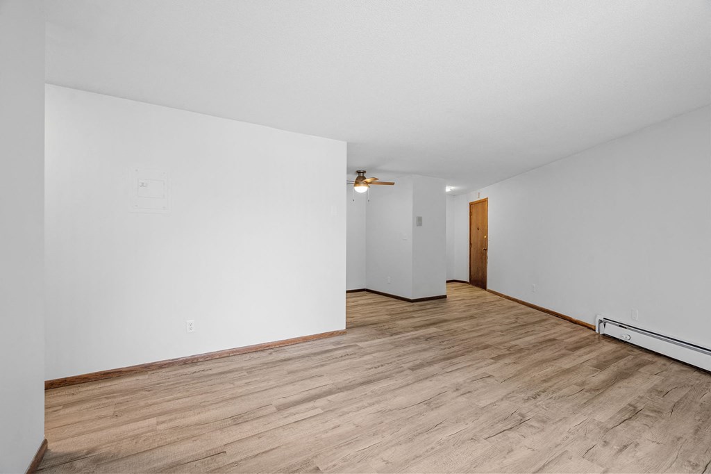 a living room with white walls and wood floors