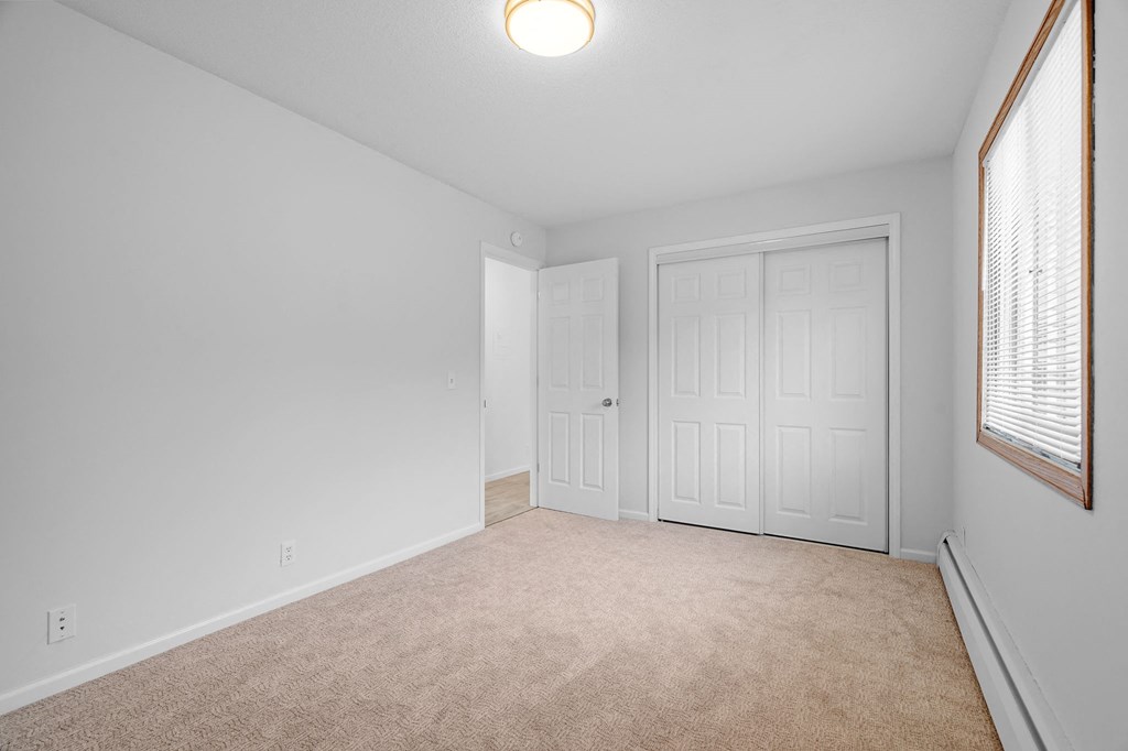 an empty living room with white walls and a white door and window