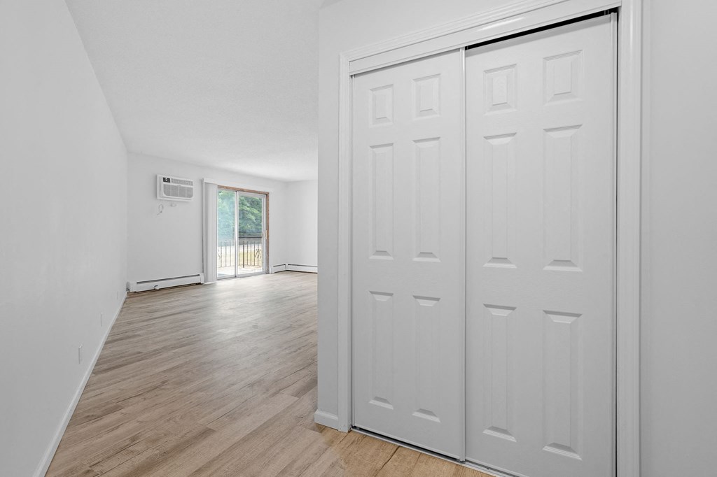 the living room and dining room of a house with white walls and doors
