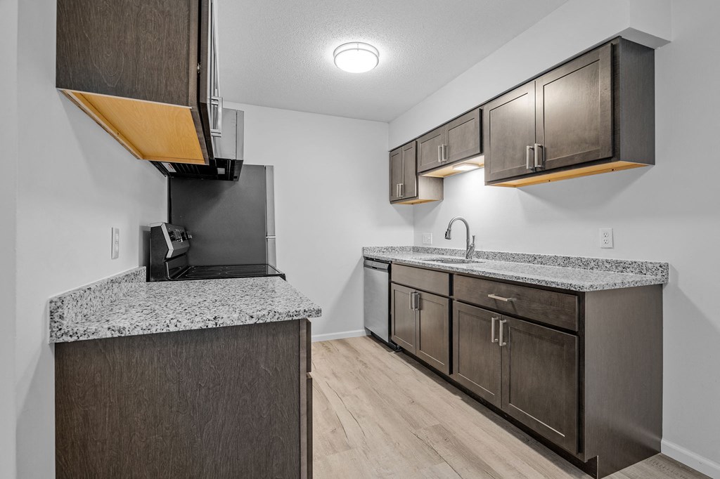 the kitchen of our studio apartment atrium with granite counter tops and wooden cabinets