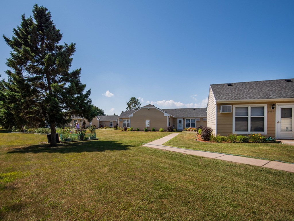 a row of houses in a yard with a sidewalk