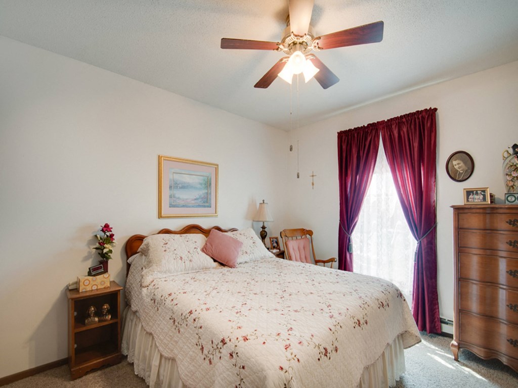 a bedroom with a bed and a ceiling fan
