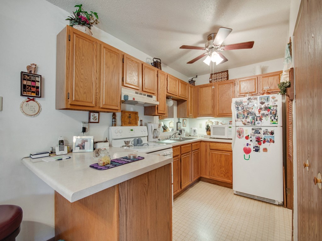 a kitchen with white appliances and wooden cabinets