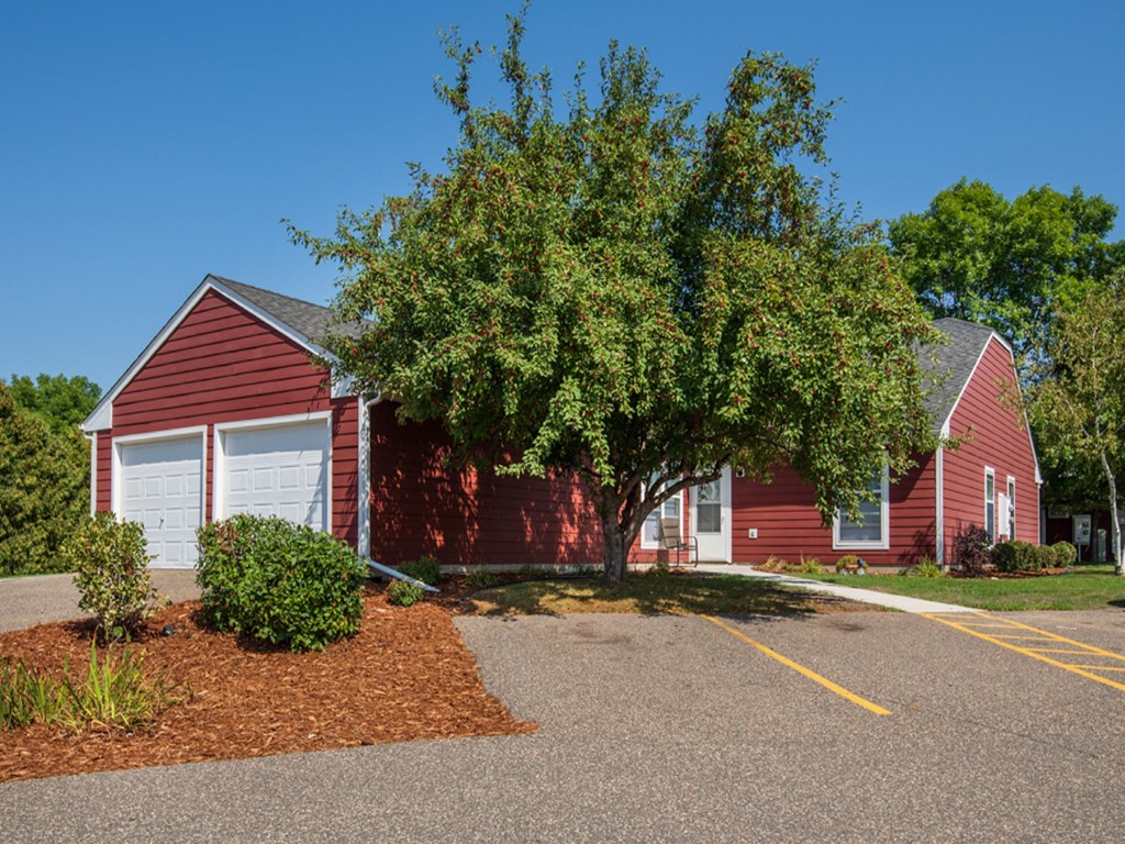 a red house with a tree in front of it