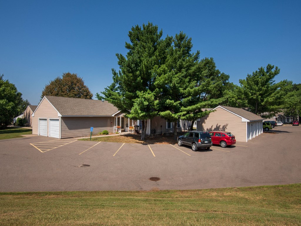 a parking lot with two cars in front of a house