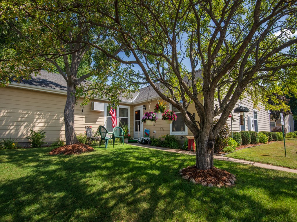 a house with a lawn and trees in front of it