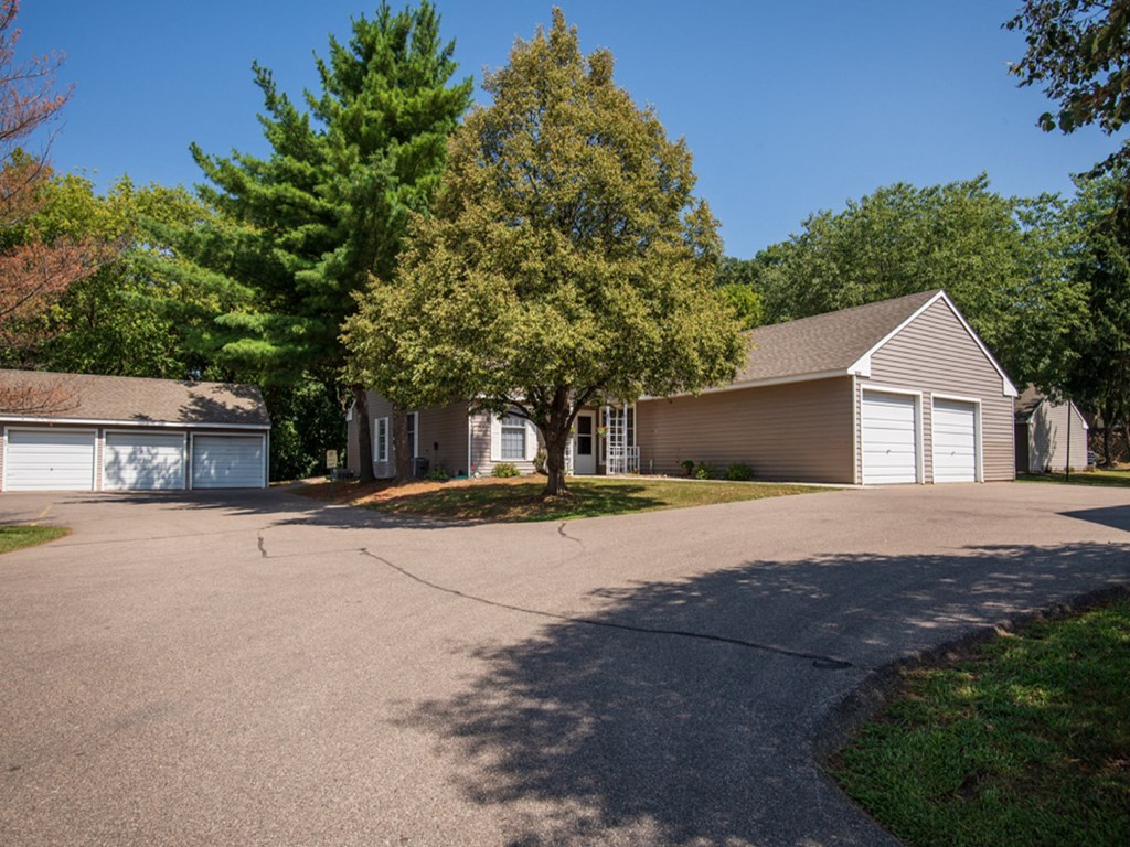 a house with a driveway and a tree in front of it
