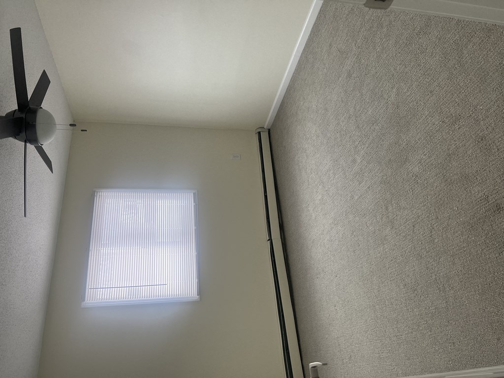 a room with a ceiling fan and a window