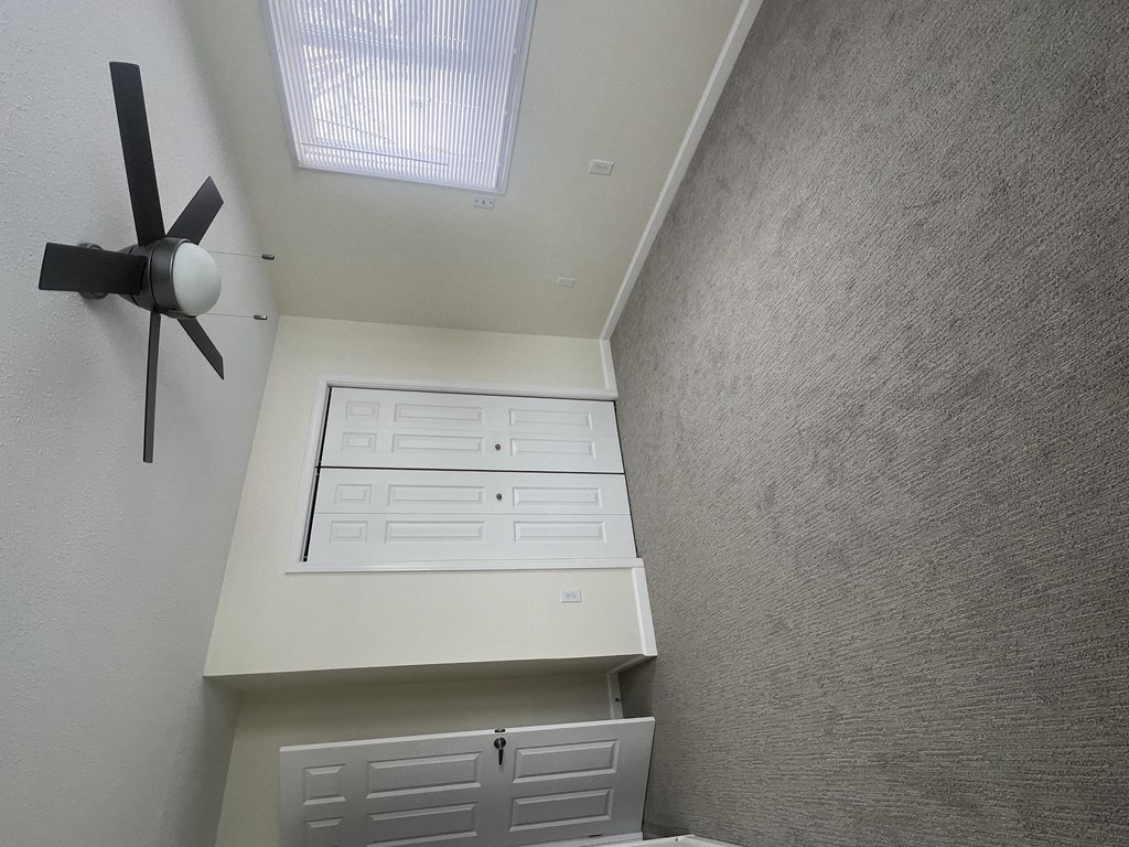 a room with a closet and a ceiling fan