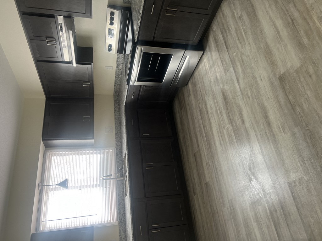 a view from above of a kitchen with black cabinets and a window