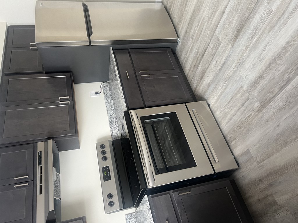 an overhead view of a kitchen with black cabinets and stainless steel appliances