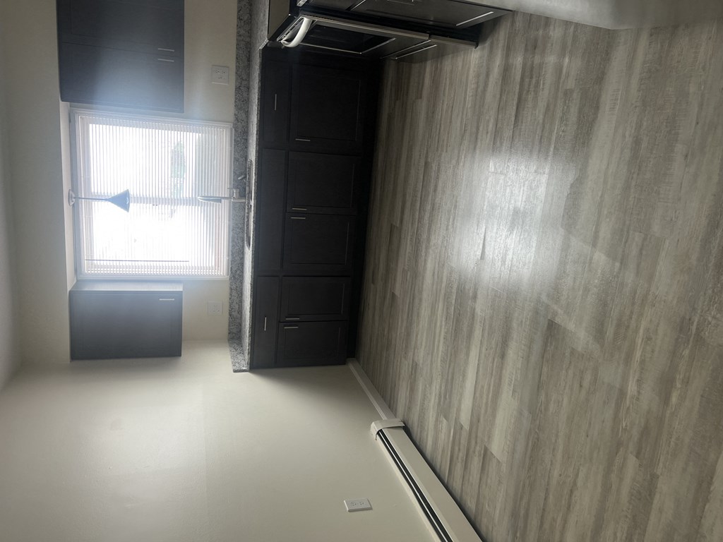 an empty room with a wardrobe and a window