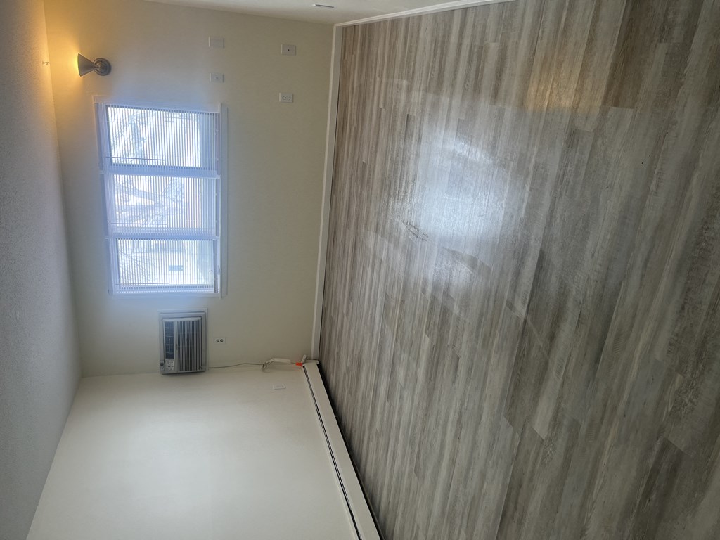 a room with a wood wall and a window and a white floor