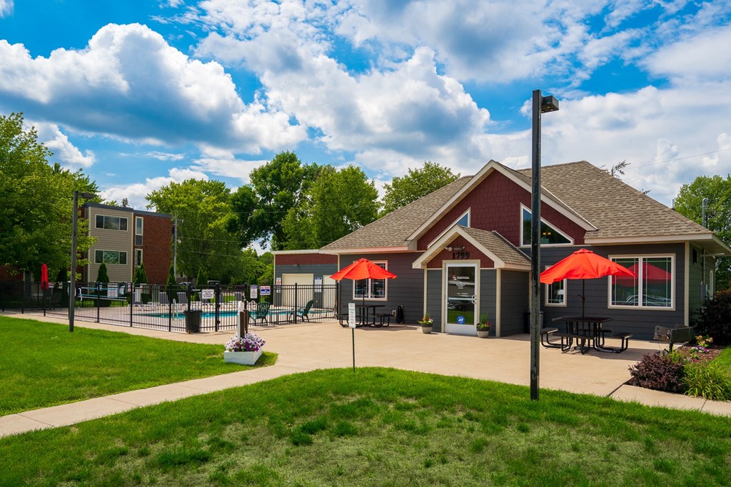 a patio with umbrellas in front of a building