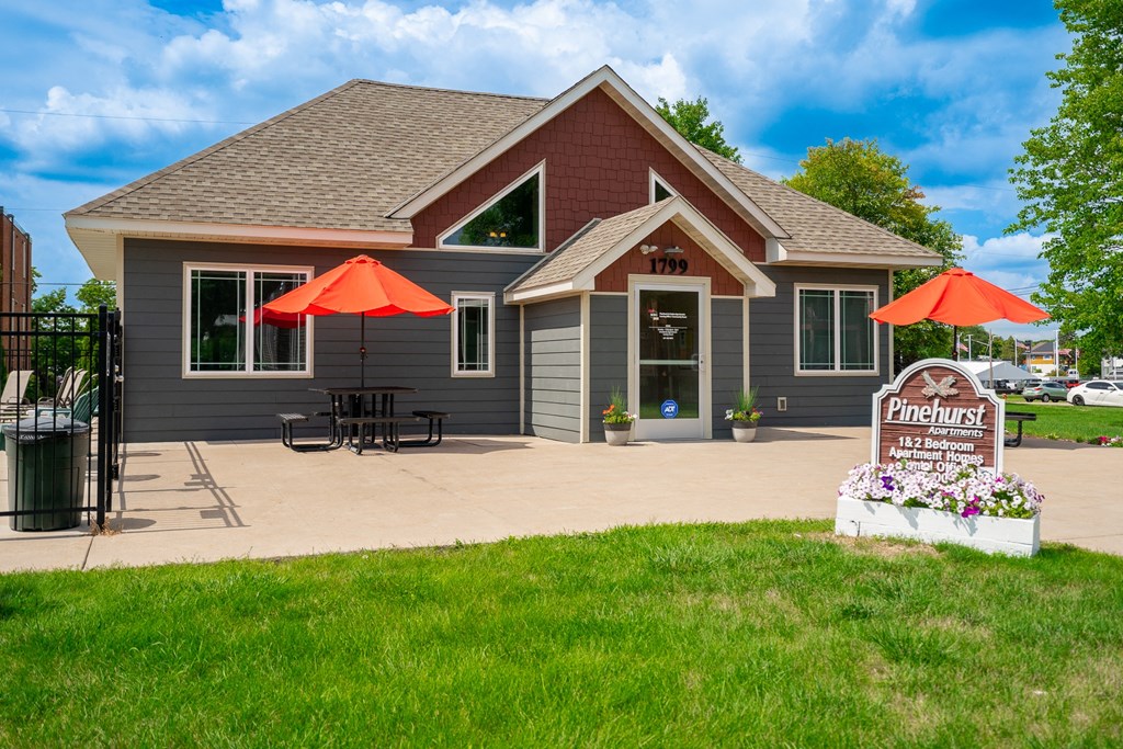 a patio with umbrellas in front of a house