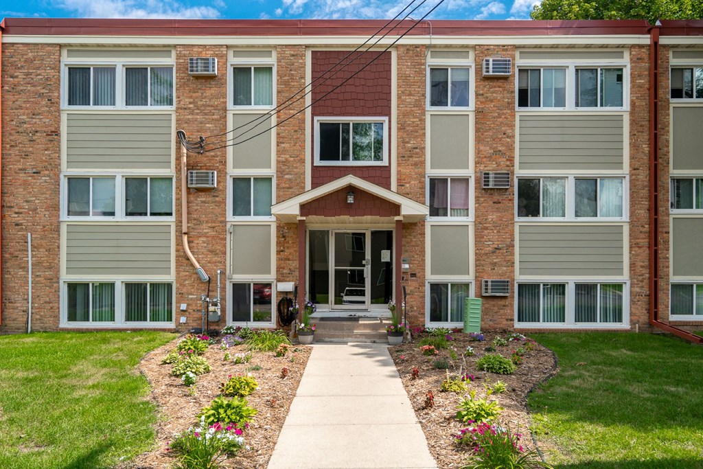 an apartment building with a sidewalk in front of it